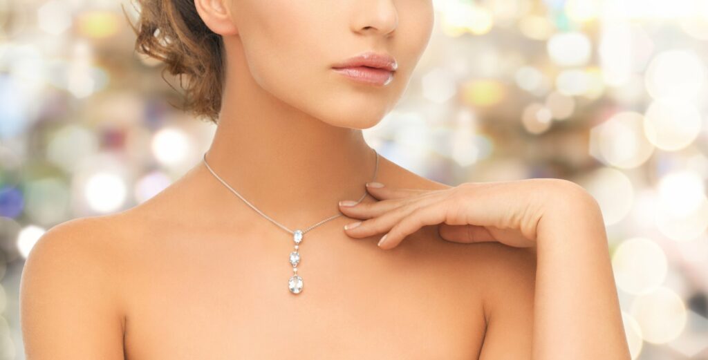 A Woman Wearing A Shiny Lab-Grown Diamond Pendant Necklace.